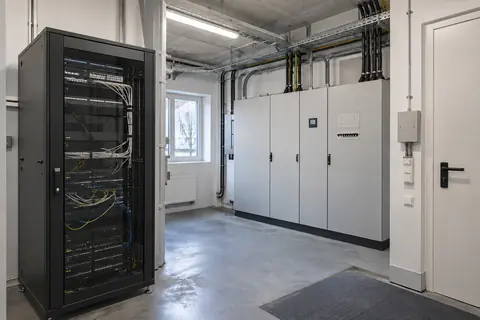 Netzwerktechnik im Technikraum · KI-Beispielvisualisierung